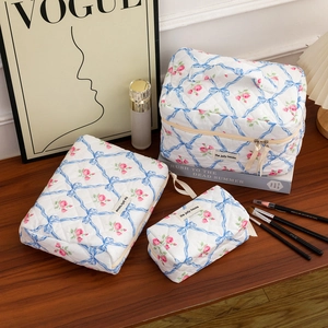 Three-piece quilted makeup bag set with blue bow and pink rose floral print patterns