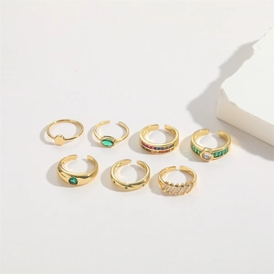 7-piece gold adjustable ring set with green emerald cubic zirconia on white stone