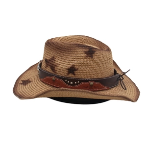Detail of a brown cowboy straw hat featuring star prints and a studded leather band