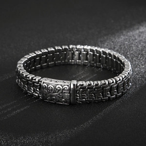 Close-up of retro titanium tree of life bracelet with woven chain and engraved clasp