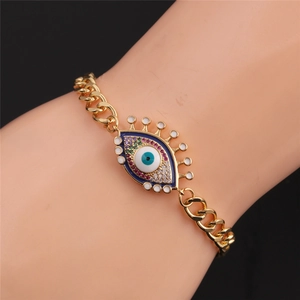 Detail of gold evil eye bracelet with colorful zircons on a model's wrist with black background