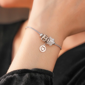 Macro shot of silver snake chain bracelet featuring heart charms and crystal beads