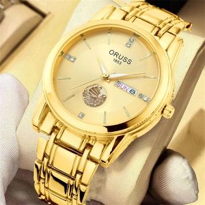Detailed close-up of golden quartz watch dial with sailboat logo and dual calendar display
