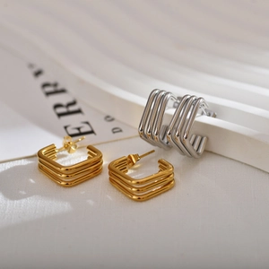 Detail of square layered earrings in gold and silver finish with 18K plating texture