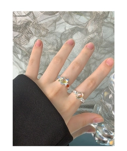 Close-up of S925 silver rings with colorful zircon and opal stones on a model's hand