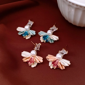 Détail de boucles d'oreilles vintage avec pétales en émail et accents de perles centrales