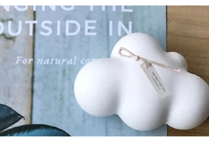 Primer plano del molde para vela aromática en forma de nube con cuerda y etiqueta