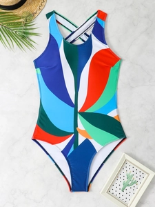Detailed flat lay of a backless one-piece swimsuit with abstract print and cross straps