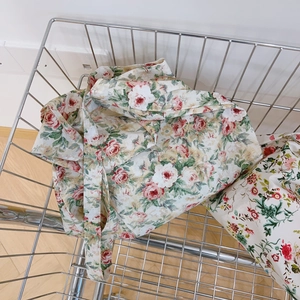 Detail of vintage red floral cotton tote bag with wide straps in a wire basket