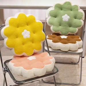 Soft flower shaped plush seat cushions in pastel colors on minimalist chairs
