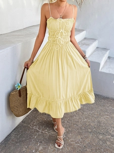 Detail of yellow high waist dress featuring ruffles and adjustable drawstring waist