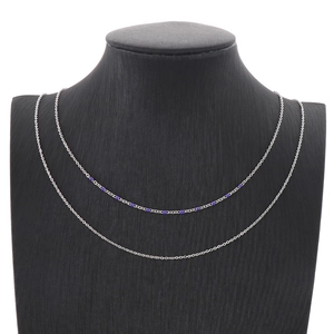 Vue détaillée du collier double couche argenté avec perles violettes sur un support à bijoux