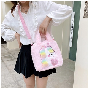 Detail of pink plush unicorn shoulder bag with rainbow mane and embroidered heart