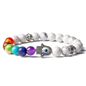 Vue macro des perles 7 Chakras avec main de Hamsa et œil bleu sur bracelet en pierre blanche