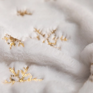 Plush white Christmas tree skirt with golden snowflake sequins for festive holiday decor