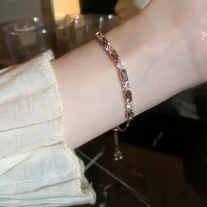 Elegant adjustable gold bracelet with sparkling zircon stones worn on a woman's wrist