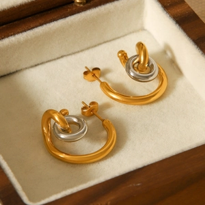 Detail view of interlocking gold and silver rings presented in a luxury wooden jewelry box