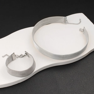 Détail du collier choker en maille argentée et de l'ensemble de bracelets tissés assortis