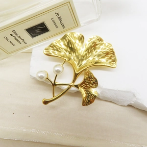 Elegant 18k gold plated stainless steel ginkgo leaf brooch with pearls on white stone