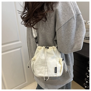 Detalle del bolso de nailon blanco con cierre de cordón y etiqueta textil de moda