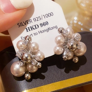 Detail of cluster pearl earrings with cubic zirconia on a silver card backing
