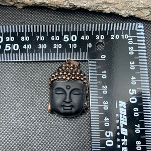 Macro view of crystal Buddha pendant with bronze trim measuring 40mm in height