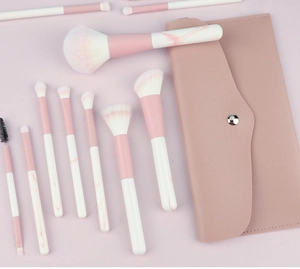 Flat lay of pink makeup brush set with marble handles and matching faux leather storage case