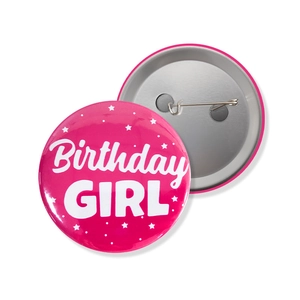 Close-up of pink Birthday Girl tinplate badge with metal pin back for party decoration