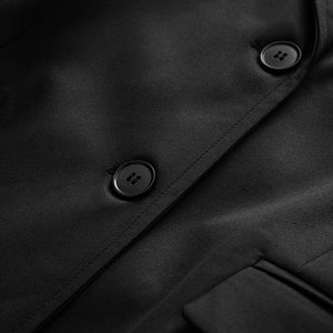 Close-up of black twill fabric texture and resin buttons on a slim-fit blazer
