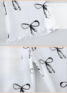 Détails de leggings en coton côtelé blanc pour enfants avec motifs nœuds et bords ondulés