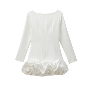 Détail de la robe blanche à manches longues avec ourlet élégant à motifs pétales 3D