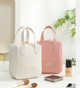 Close-up of shell-shaped PU leather toiletry bags with elegant handles and metal zippers