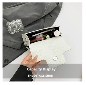 Detail view of the interior capacity of a white crocodile embossed faux leather handbag