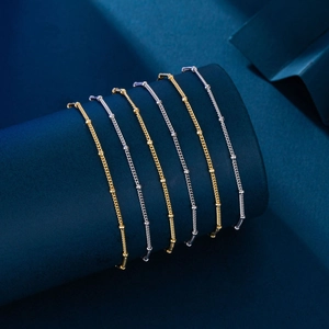 Minimalist S925 sterling silver beaded bracelet in gold and silver finishes on a blue stand