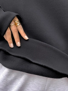 Detail of black sweatshirt showing ribbed cuffs and soft fleece lining texture