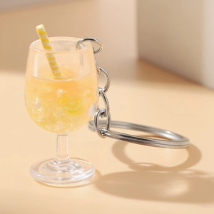Detailed view of miniature lemon goblet keychain with yellow drink and striped straw