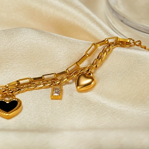 Detail of 18K gold double-layer bracelet with black heart, zircon and satin backdrop