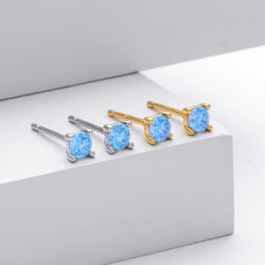 Detailed macro view of S925 silver and gold stud earrings with round blue zircons