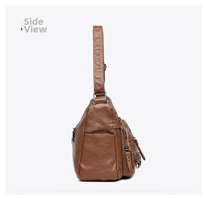 Side view detail of brown leather crossbody bag with multiple zippers and pebble texture