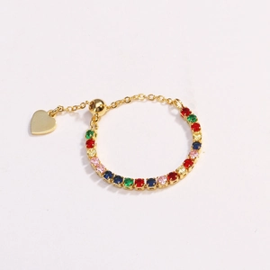 Close-up of golden adjustable chain ring featuring colorful zircons and heart charm