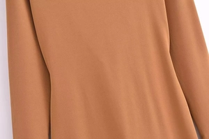 Close-up of elegant camel cowl neck dress showing premium fabric texture and seams