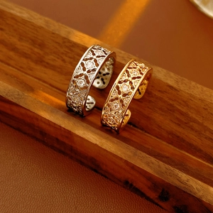 Close-up of gold and silver plated flower rings with intricate hollow patterns and zircons