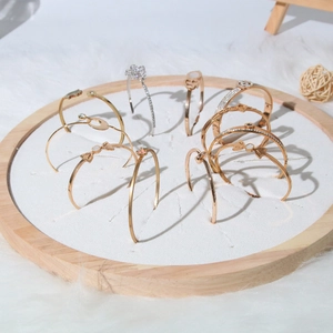 Wooden display tray with assorted rose gold and silver luxury bangles on white fur