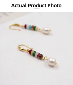 Detail view of ethnic style drop earrings with colorful beads and white teardrop pearls