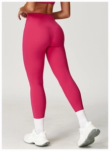 Detail of high-waisted seamless yoga leggings in vibrant rose pink with body-shaping fit
