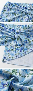 Detailed view of blue floral swimsuit waist featuring pleated knot and elastic waistband