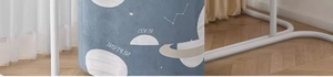 Close-up of blue fabric storage ottoman with gold Neptune and Venus space themed prints