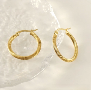 Detailed view of gold plated twisted hoop earrings with textured spiral design and latch back