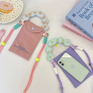 Détail de mini sacs de téléphone en toile rose et violet avec broderie de poignée nuage
