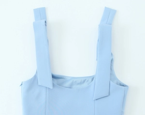 Close-up of light blue top with elegant square neckline and pleated wide shoulder straps